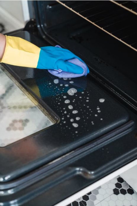 Placeholder photo — cleaning inside an oven, the kind of spot a standard clean skips. Swap for a real Magic Maids job-site photo.