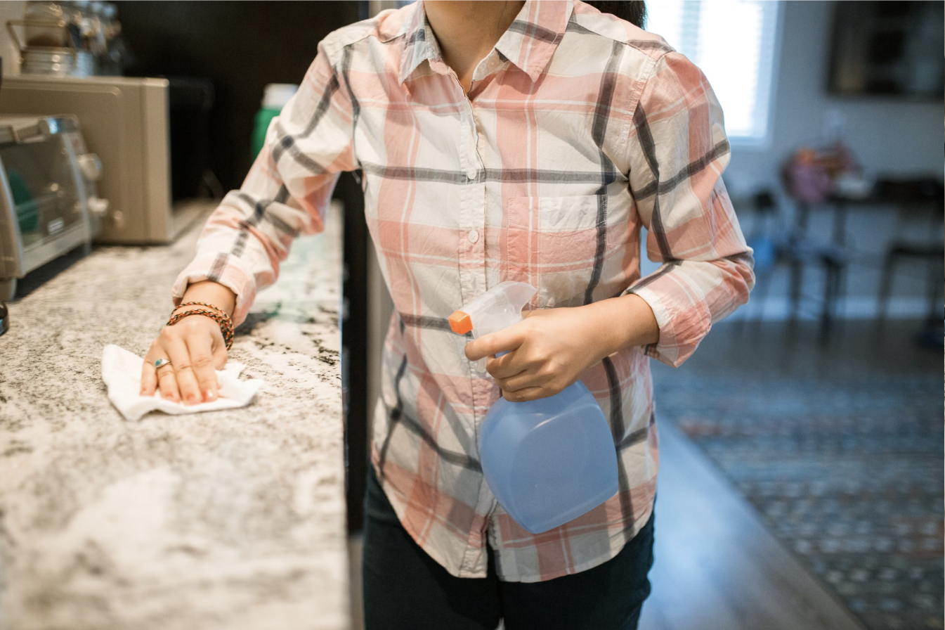 Placeholder photo — someone wiping down a kitchen counter with a spray bottle and cloth. Swap for a real Magic Maids job-site photo.